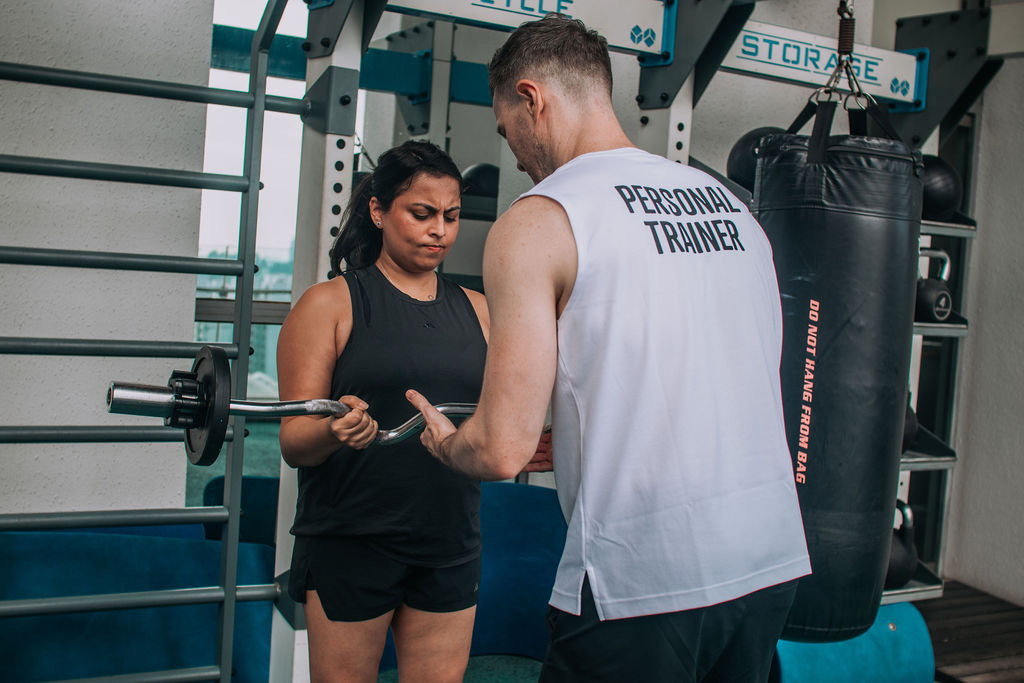 A FitBeat coach guiding a client through a lift