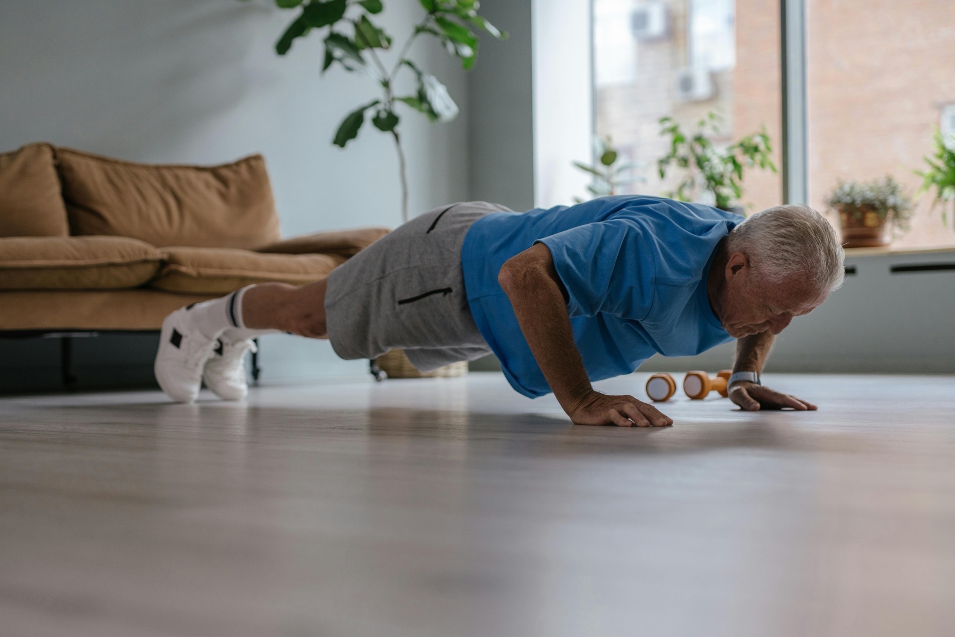 A FitBeat coach supporting an older client through a strength exercise
