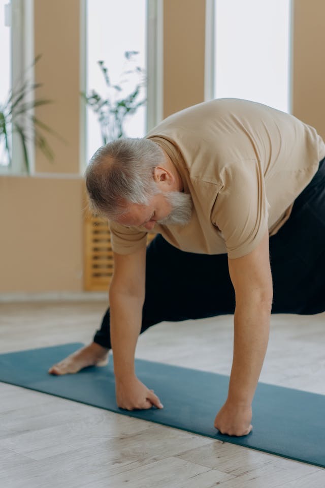An older FitBeat client lifting under coach supervision